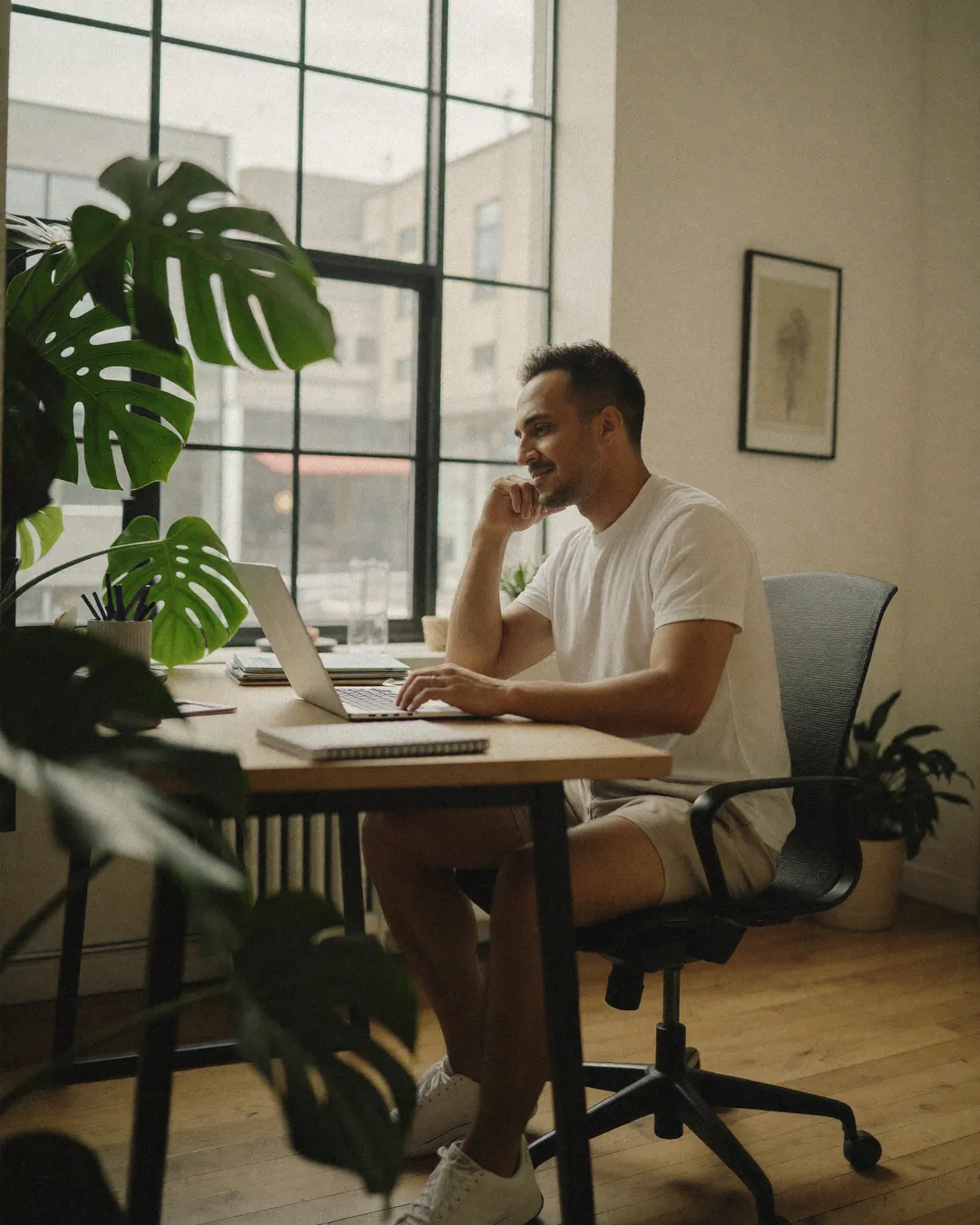 Rahim, Squarespace designer at SQSP, working at his desk by the window in his East London studio