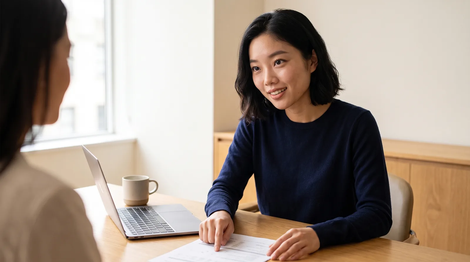 An accountant walking a small-business client through their accounts at a warm oak desk