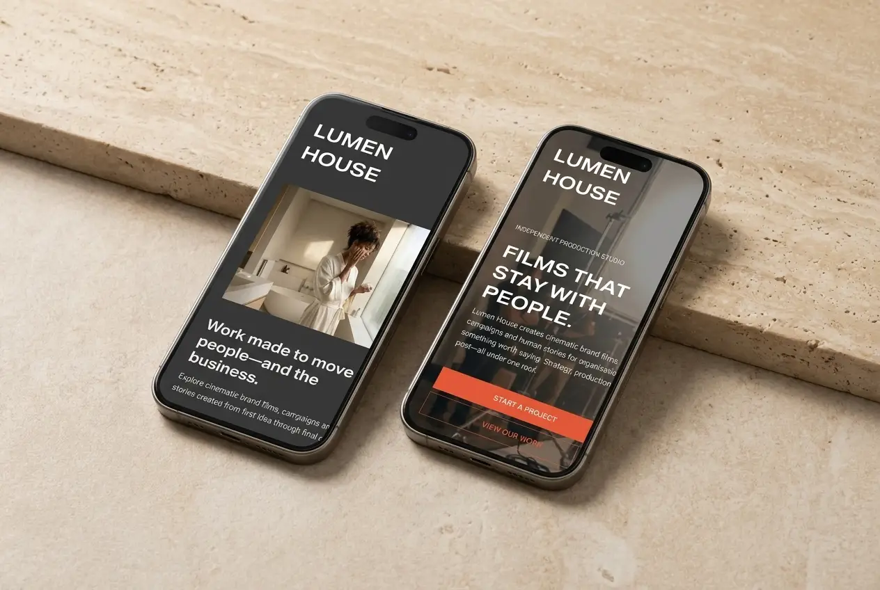 Two iPhones on warm stone showing the Lumen House template&rsquo;s mobile homepage and video portfolio page