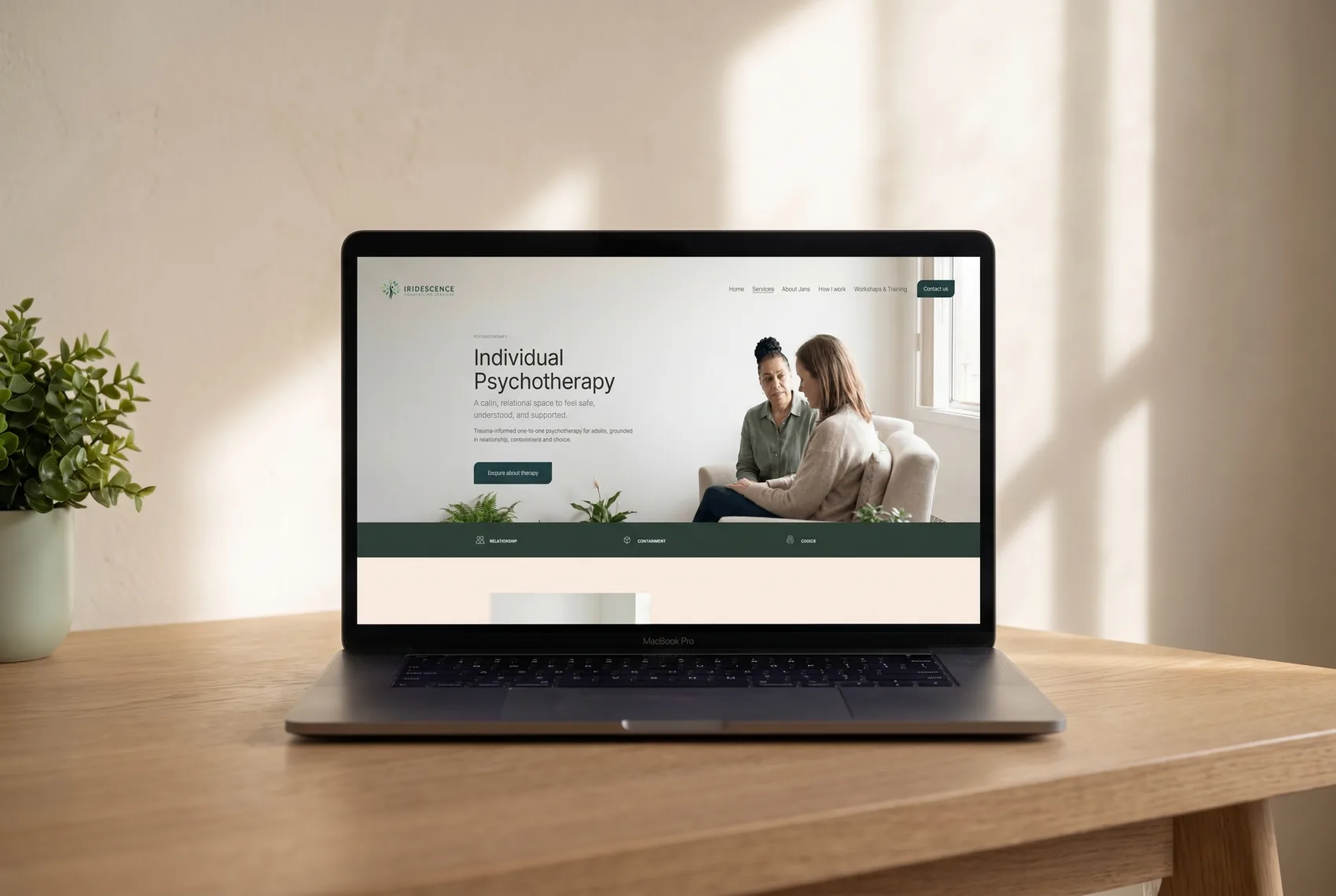 The Individual Psychotherapy page of the Iridescence Counselling Services website shown on a MacBook Pro on a warm oak desk