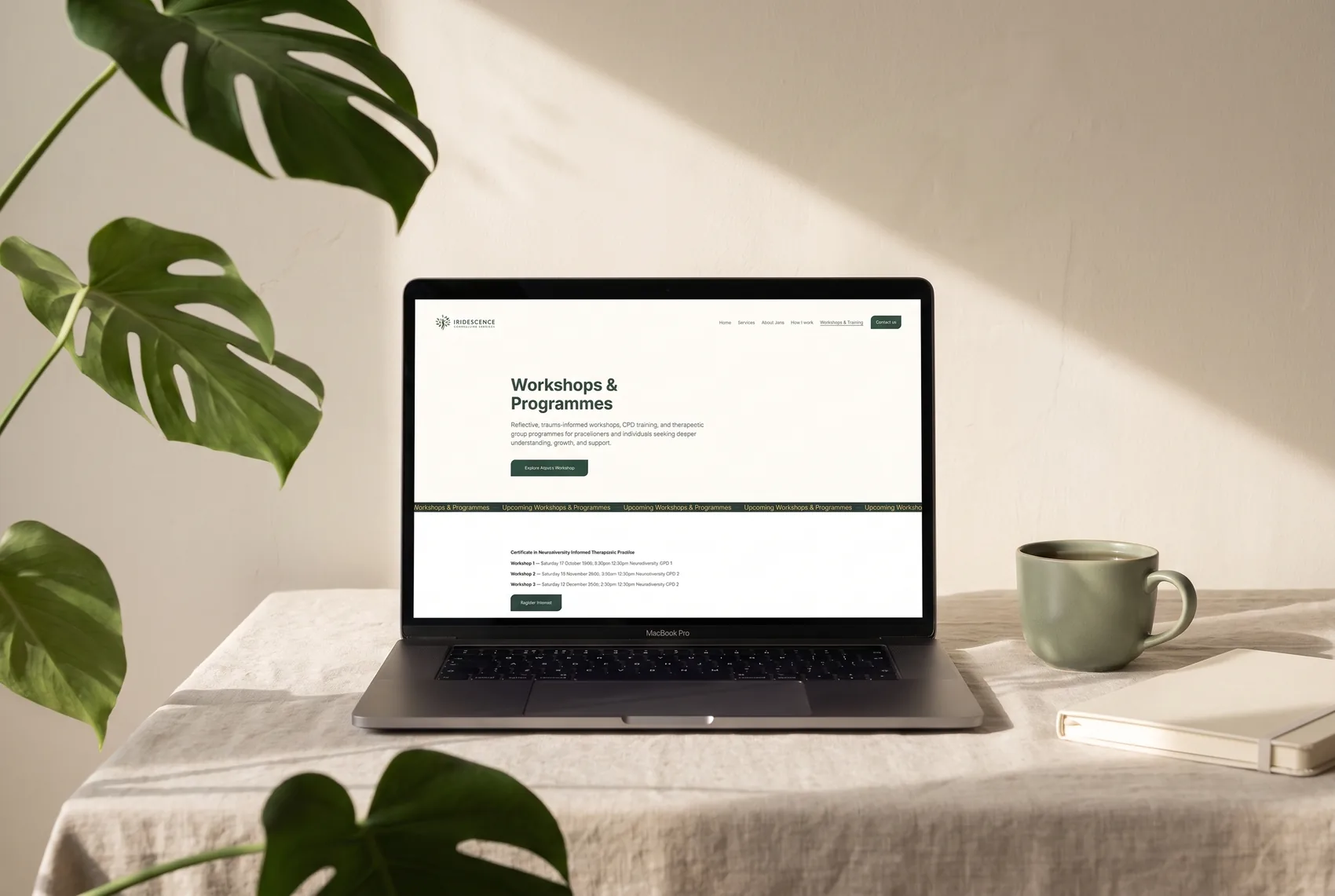 The Workshops & Programmes page of the Iridescence website with its CPD listings, shown on a MacBook on a linen-covered desk